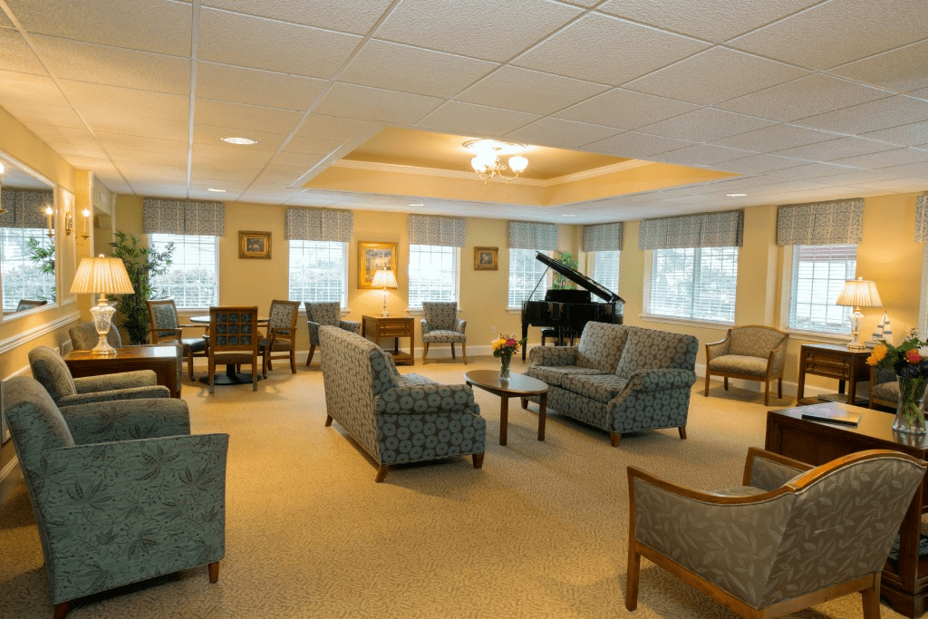 A spacious living room with multiple seating areas and a grand piano.
