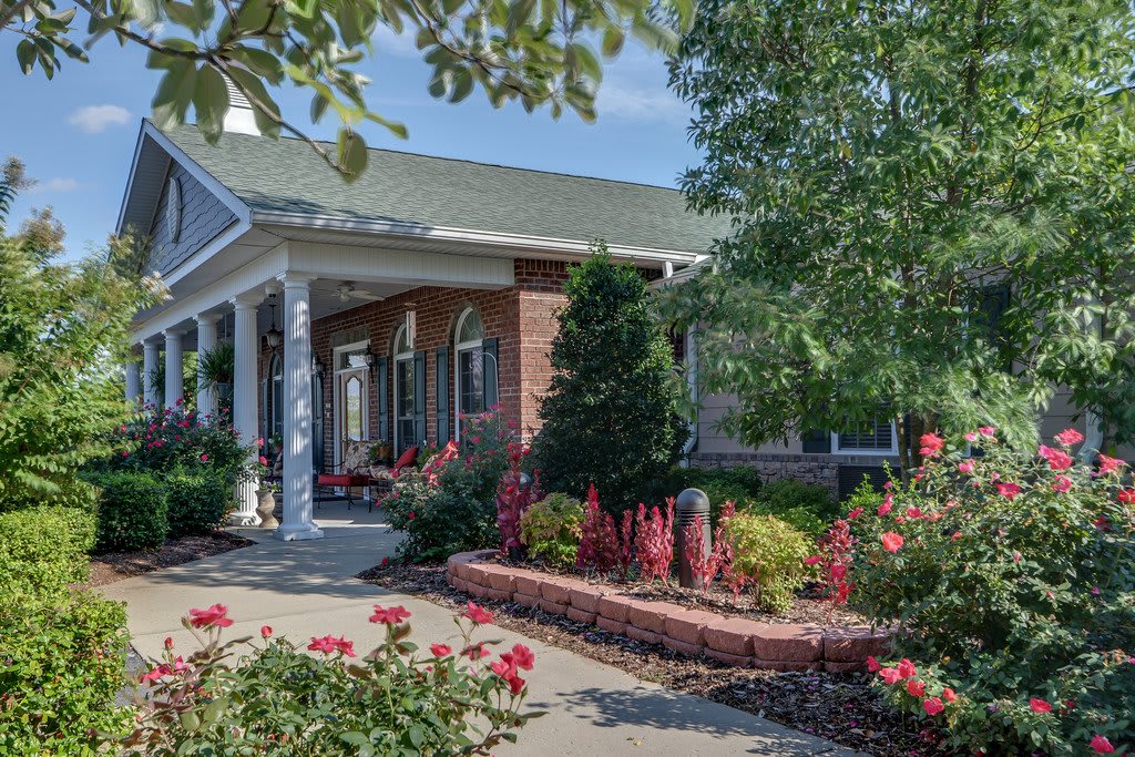 A charming house with a beautifully landscaped garden featuring colorful flowers and lush greenery.