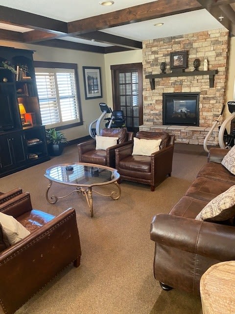 A cozy living room featuring leather furniture and a stone fireplace.