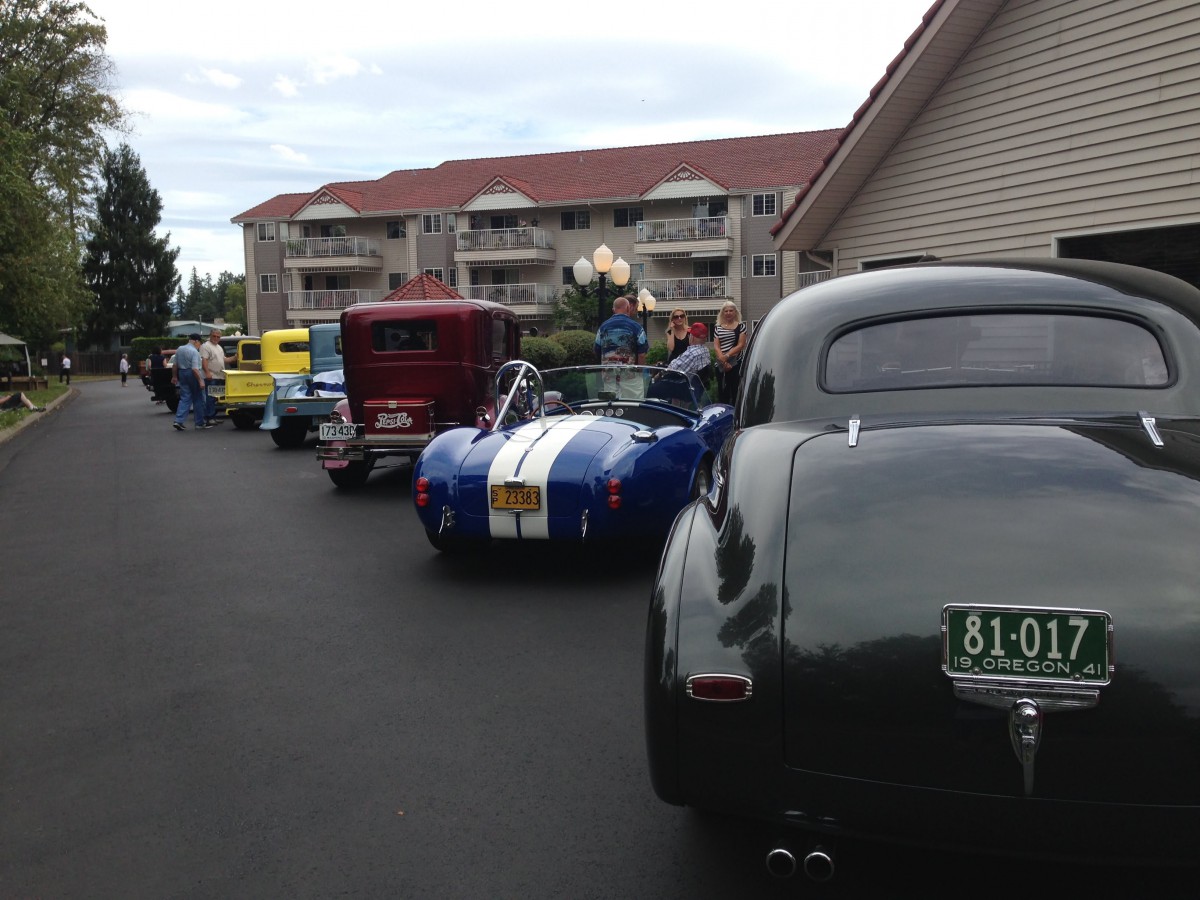A lineup of classic and vintage cars at an outdoor car show.