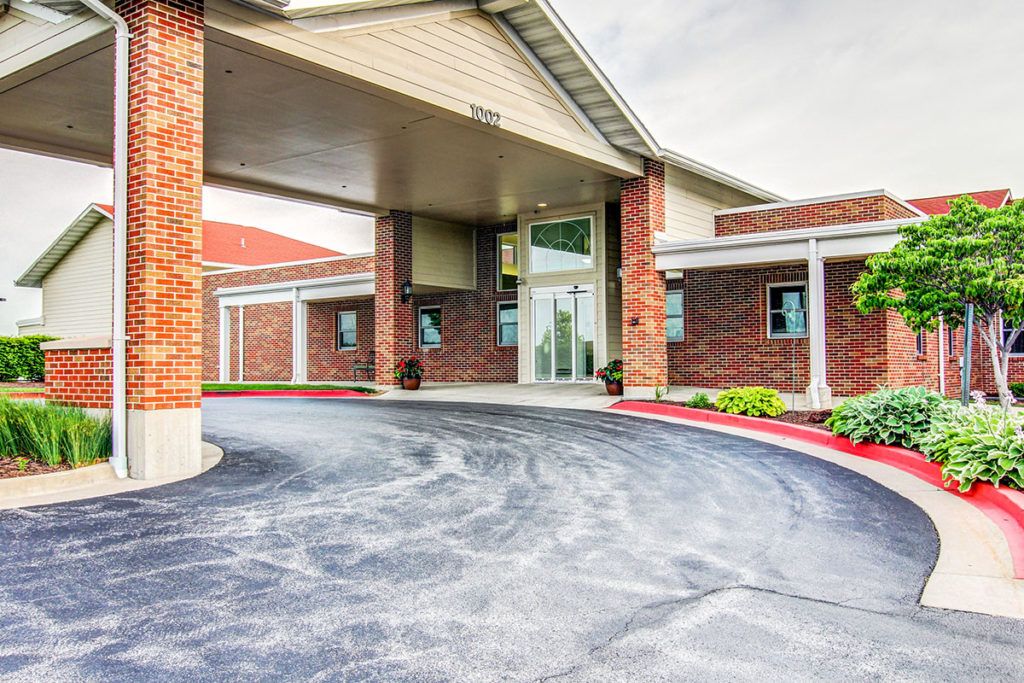 A brick building entrance with a covered driveway.