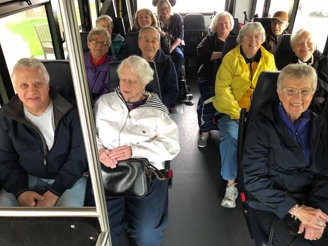 A group of seniors seated on a bus for a trip.