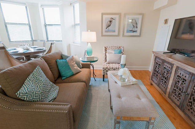 A cozy and stylishly decorated living room with a sofa, armchair, and coffee table.