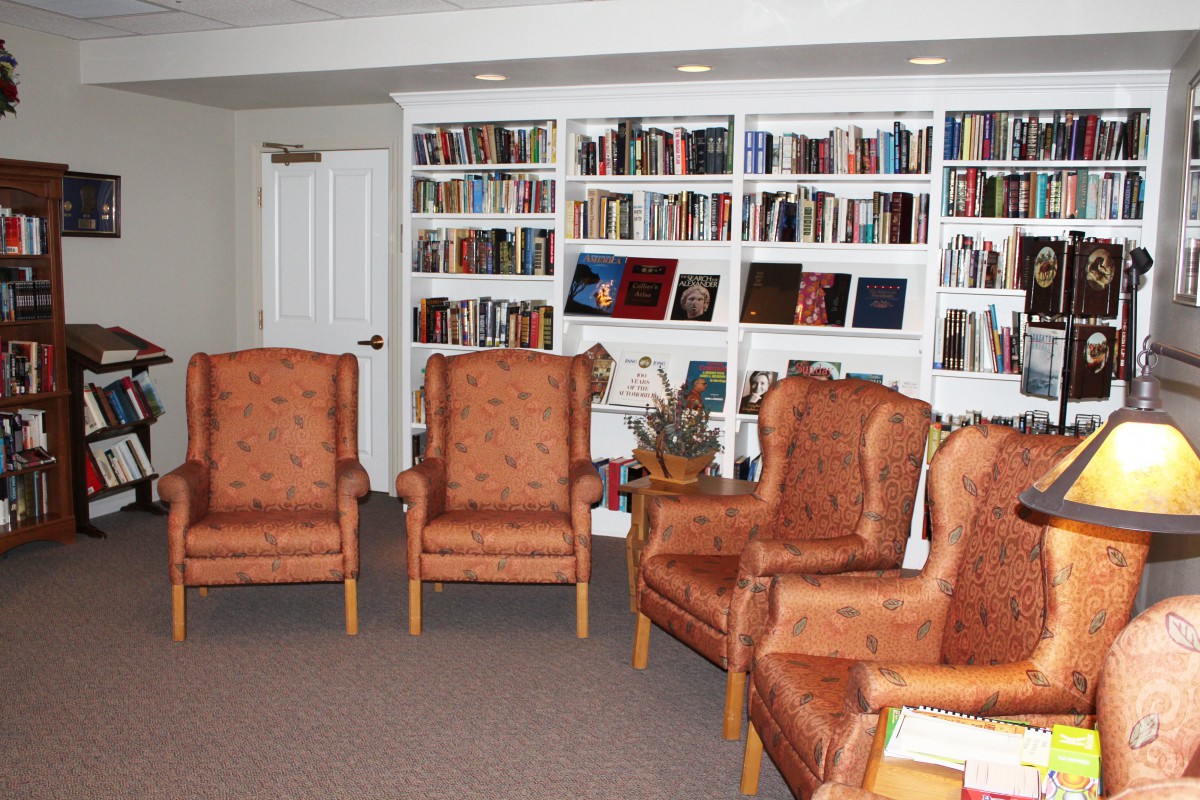 A cozy library with bookshelves and comfortable chairs.