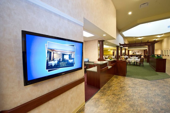 A modern lobby with a television screen and open reception area.