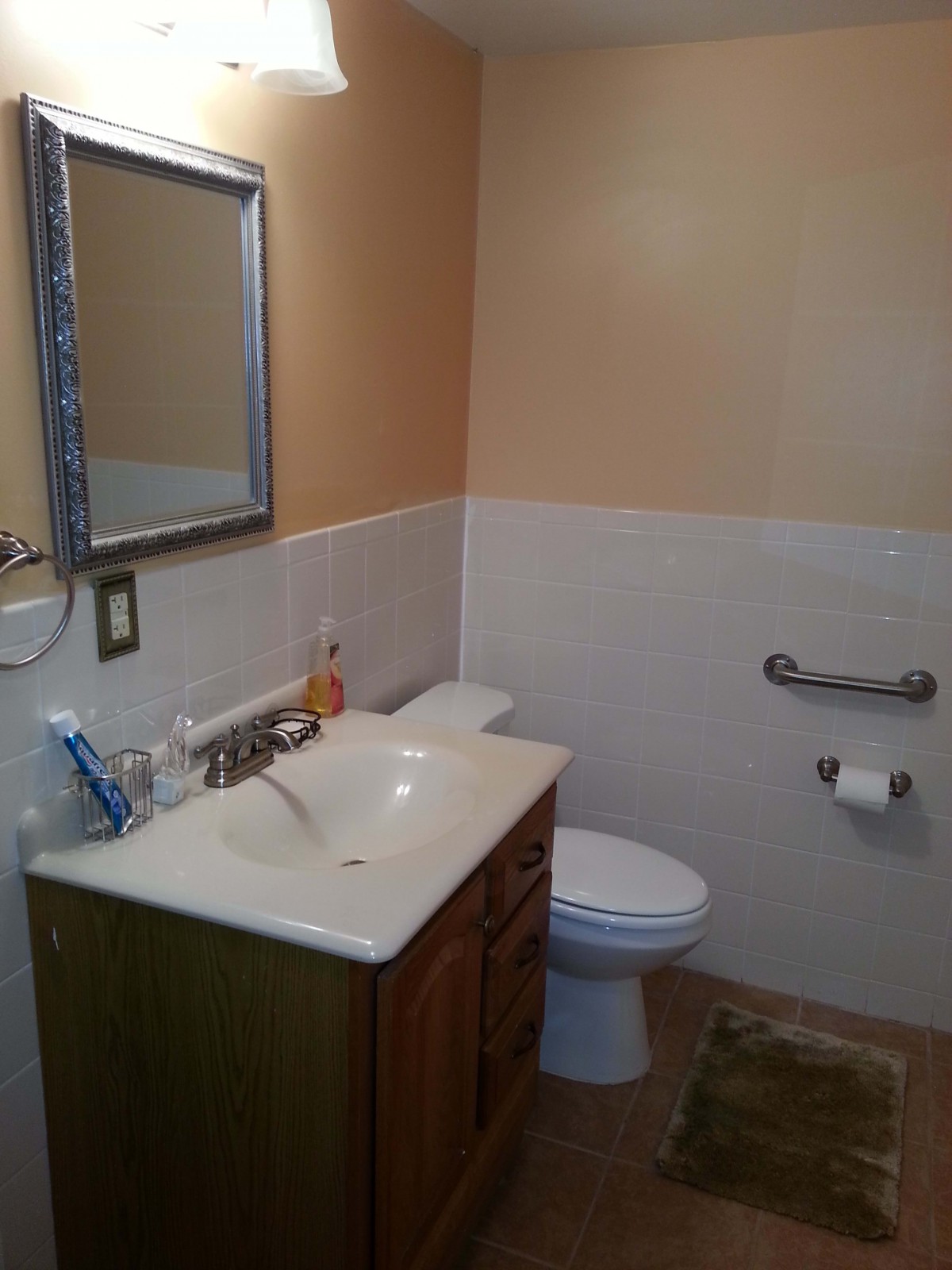 A clean and well-organized bathroom with a sink, mirror, and toilet.