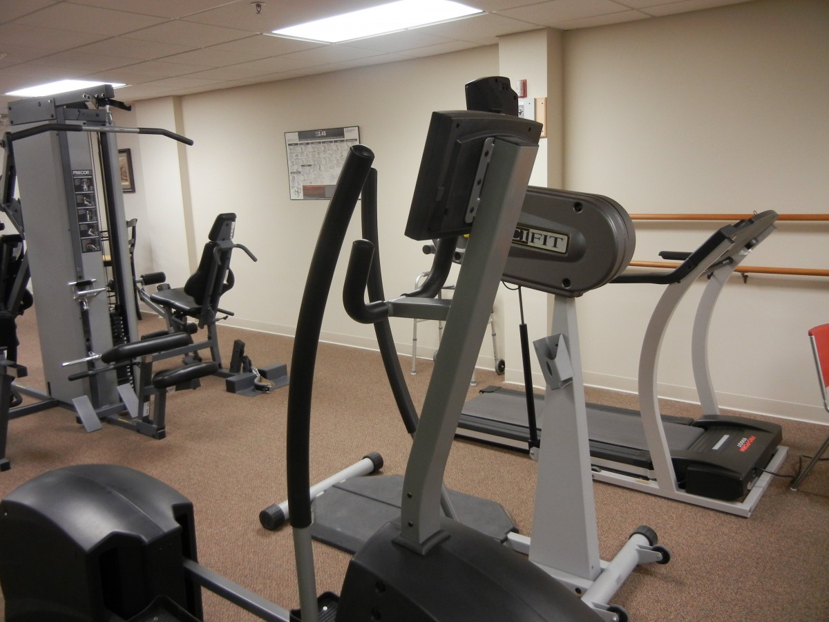 A gym with various exercise machines including an elliptical and a treadmill.