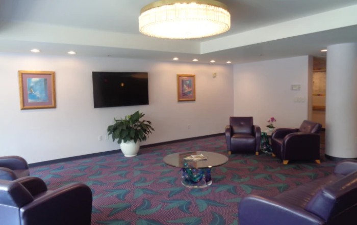 A cozy lobby with seating, television, and decor.