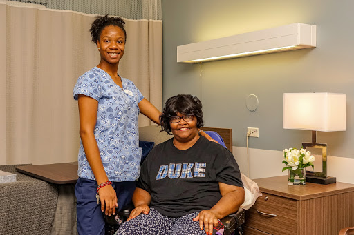 A nurse standing beside a patient in a hospital room, showcasing compassion and care.