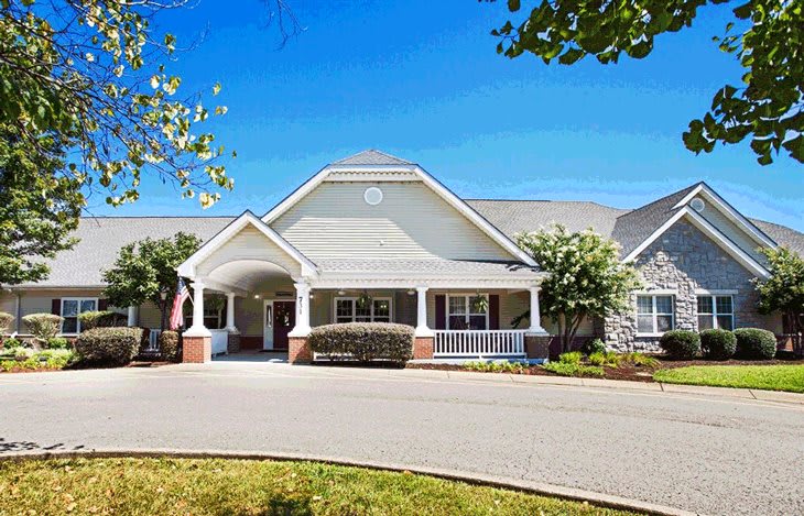 A suburban residential house with a large driveway and well-maintained landscaping.