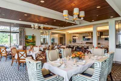A beautifully designed restaurant interior with elegantly set tables and comfortable seating.