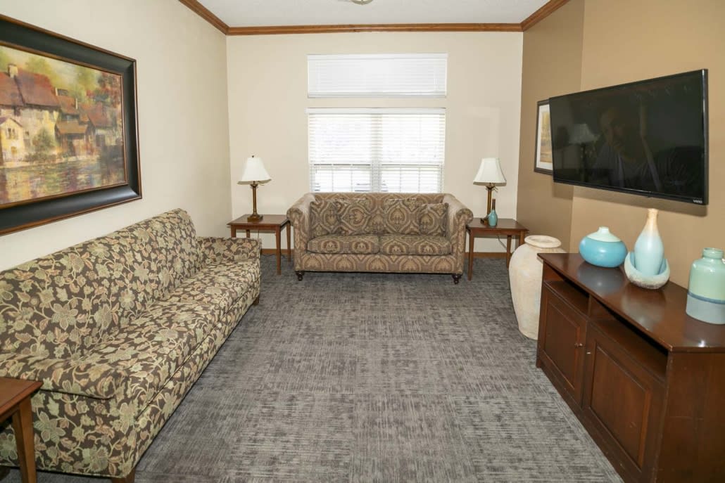 A cozy living room with two sofas, a television, and a coffee table.
