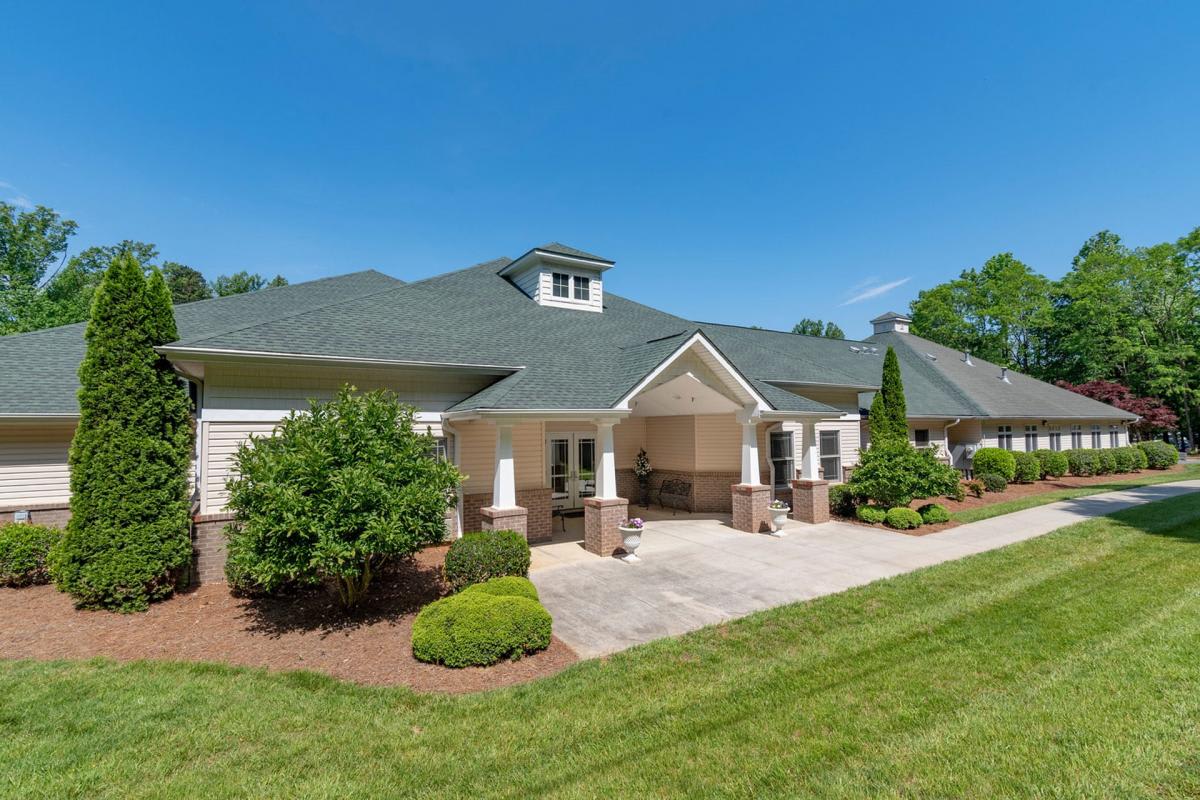 A well-maintained residential house with a landscaped lawn and clear blue sky.