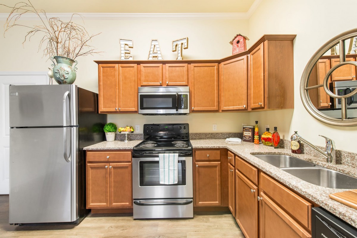 A modern kitchen featuring stainless steel appliances and wood cabinetry.