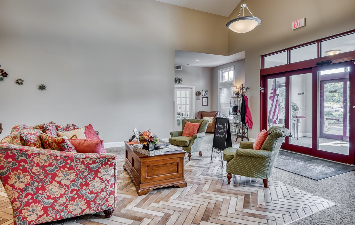 A cozy living room featuring vibrant decor and a herringbone-patterned floor.