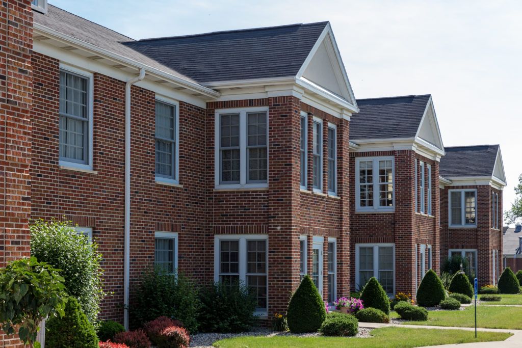 A suburban residential brick building with manicured landscaping.