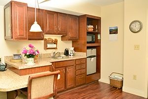 A cozy kitchen interior with wooden cabinets, appliances, and decorative elements.