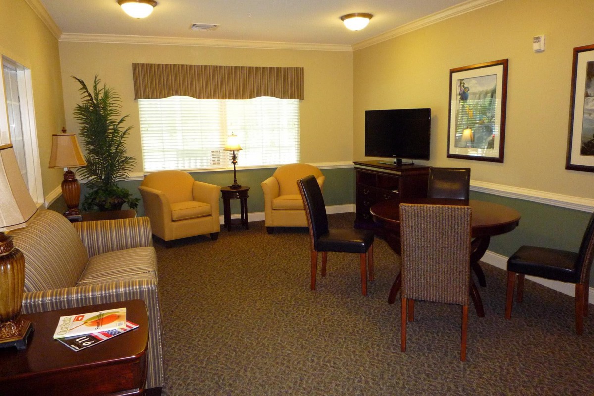 A cozy living room with comfortable seating, a television, and a table surrounded by chairs.
