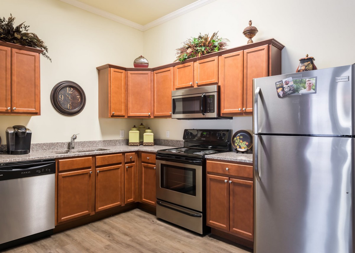 A modern kitchen featuring wooden cabinets and stainless steel appliances.