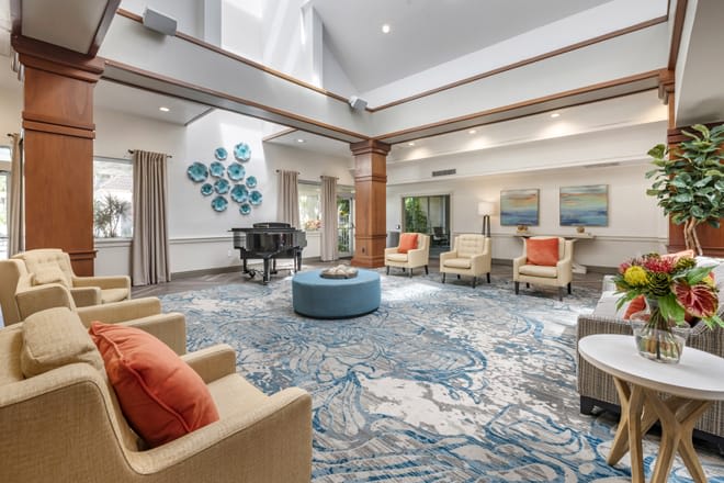 A spacious, bright lobby with comfortable seating and a grand piano.