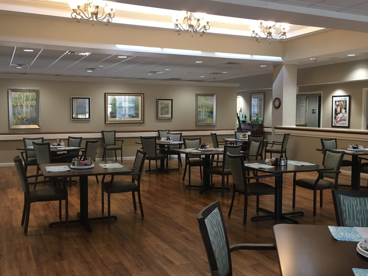An empty restaurant dining area with neatly arranged tables and chairs.