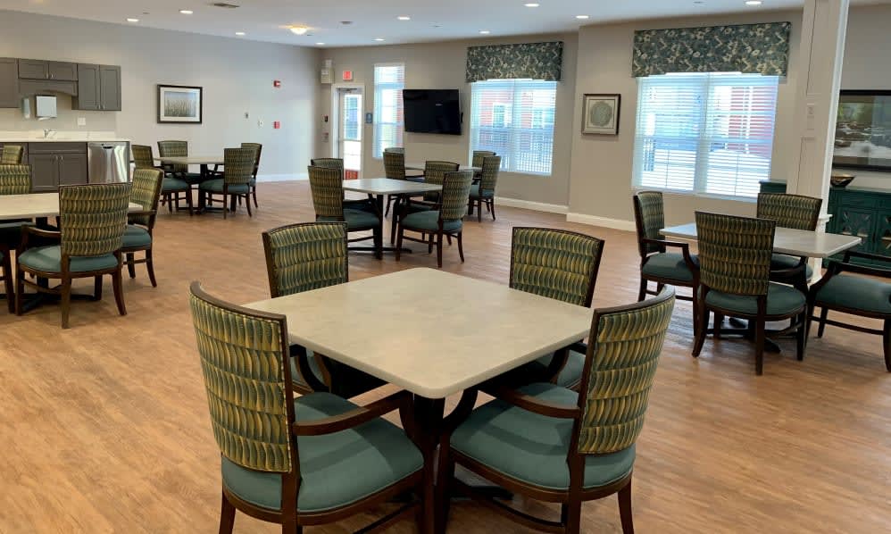 A community dining room with multiple tables and chairs arranged for gatherings.