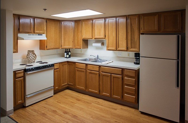 A modern kitchen with wooden cabinets and essential appliances.