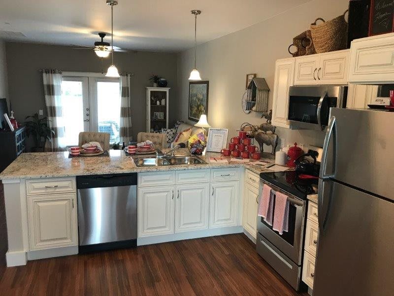 A modern kitchen with white cabinets and stainless steel appliances, featuring a cozy and inviting atmosphere.