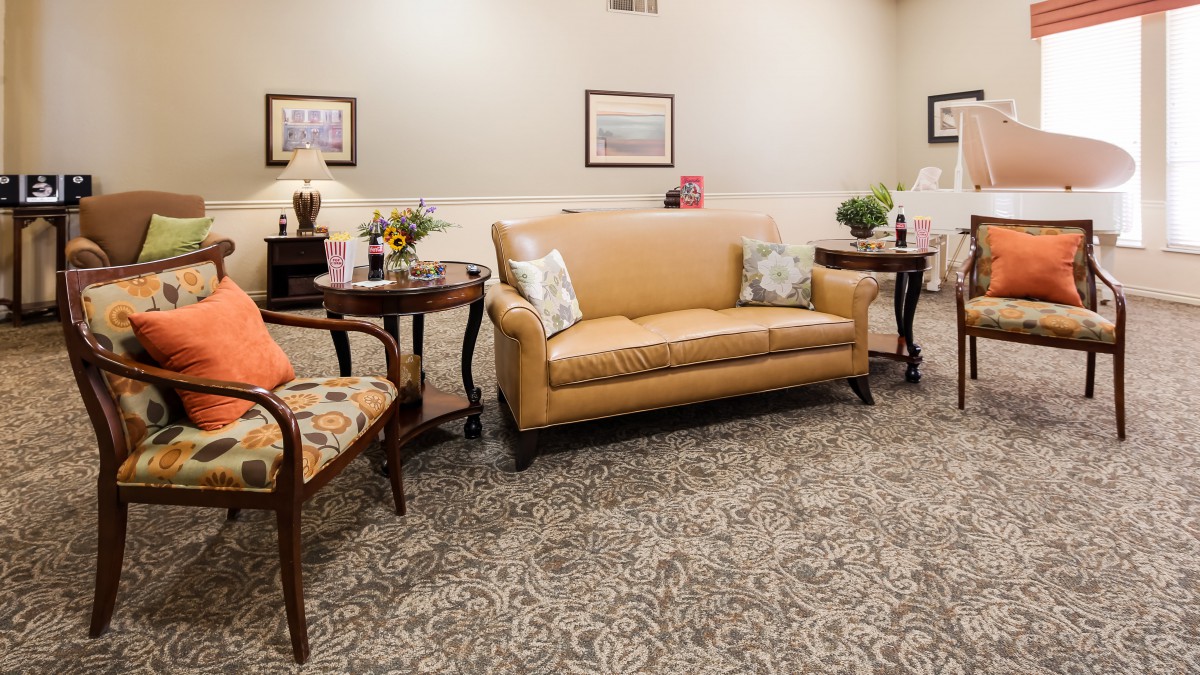 A cozy living room with a sofa, chairs, and coffee tables adorned with decorative items.