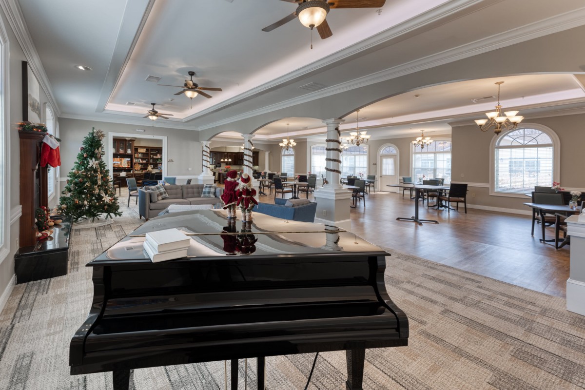 A spacious lounge area with a piano and elegant decor.