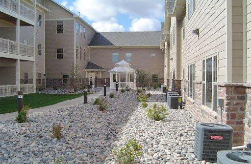 A serene courtyard featuring a gazebo surrounded by landscaped rocky areas and modern buildings.