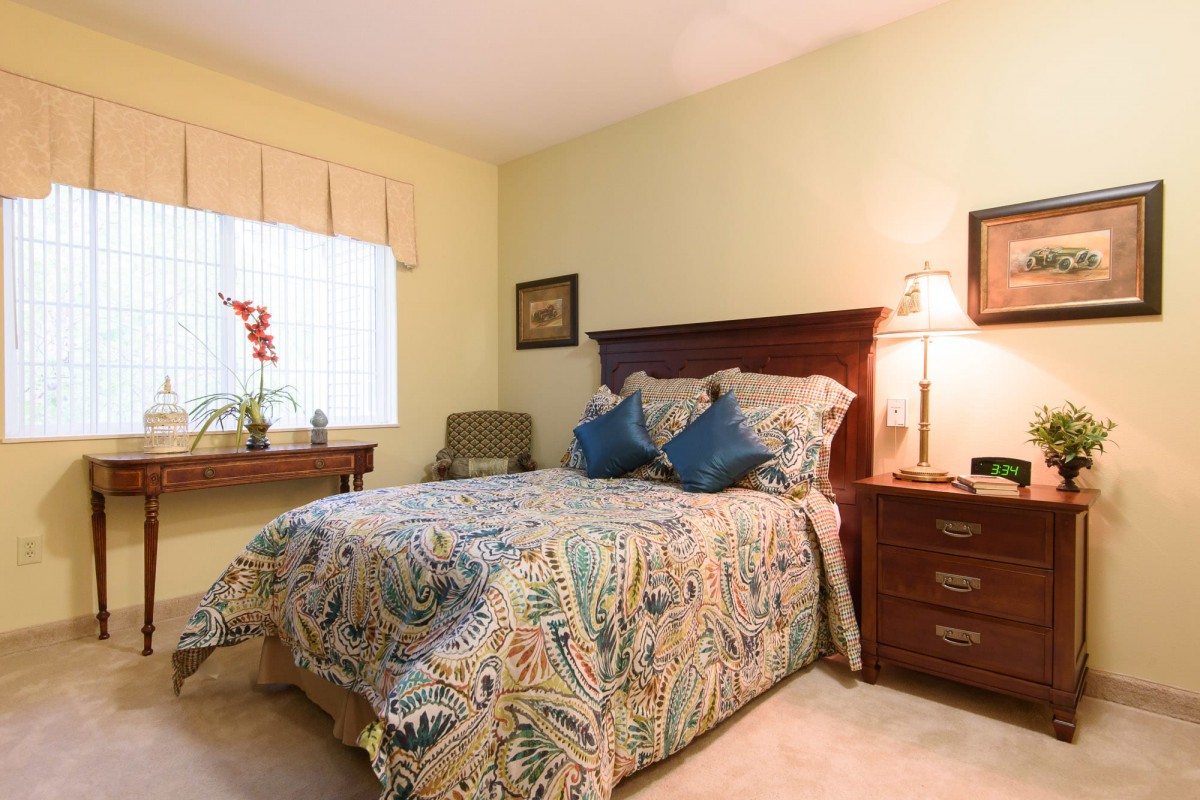 A cozy bedroom with patterned bedding and soft lighting.