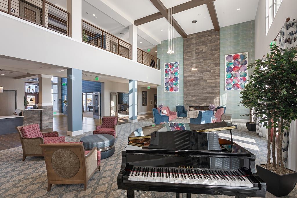 A modern lobby with a grand piano, comfortable seating, and colorful artworks.