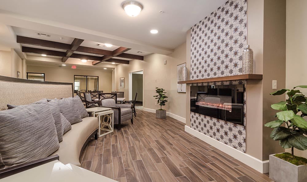 A modern living room featuring a stylish fireplace, wooden flooring, and a comfortable seating area.