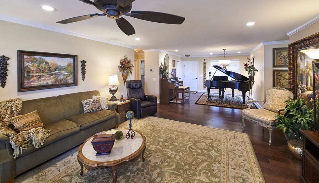 A spacious living room featuring a grand piano, cozy sofa, and elegant decor.