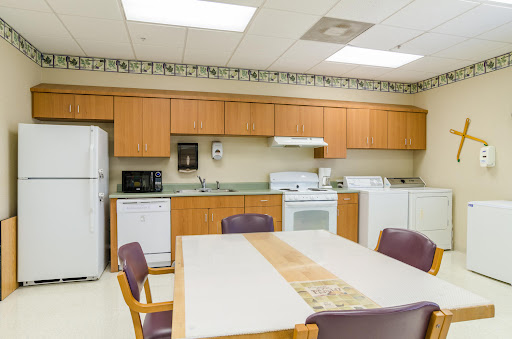 A spacious and well-equipped kitchen area featuring wooden cabinets, appliances, and a dining table.