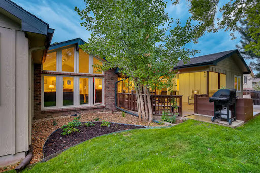 A charming house exterior showcasing beautiful landscaping and serene outdoor space at dusk.