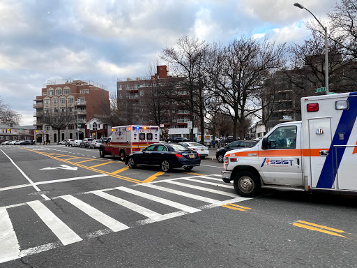 An emergency scene on a city street featuring ambulances and traffic.