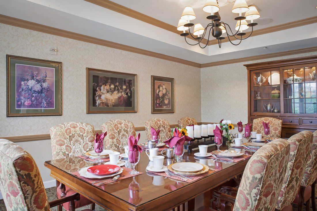 A beautifully set dining room table with elegant decor and artwork on the walls.