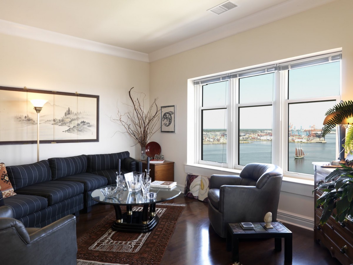 A modern living room with a large window offering a scenic view and comfortable seating arrangements.