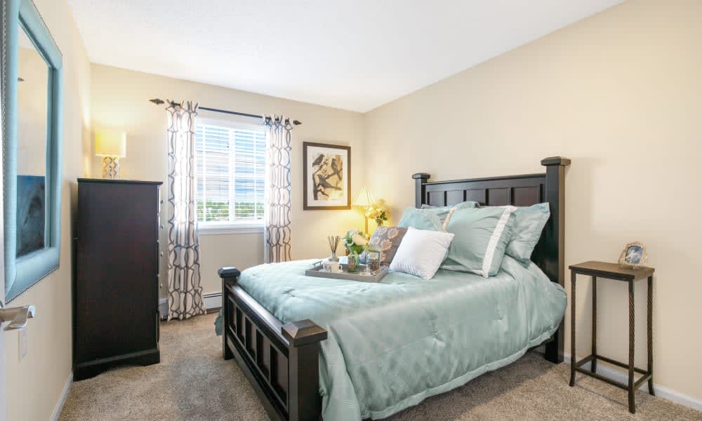 A cozy bedroom with a neatly made bed and decorative accents.