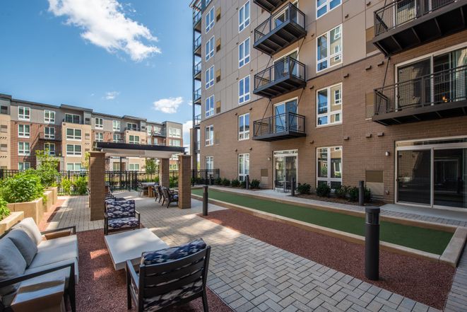 Modern apartment complex with outdoor seating and balconies.