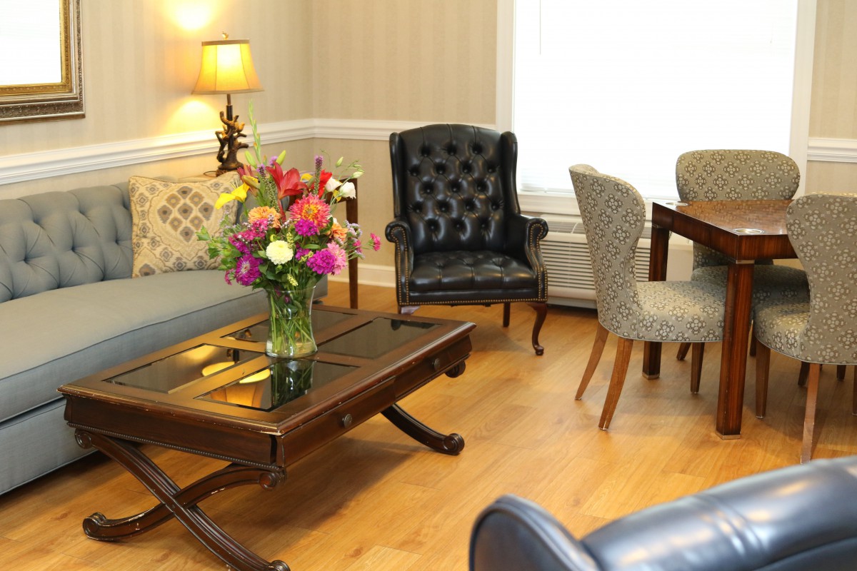 A cozy living room with elegant furniture and a bouquet of flowers on the coffee table.