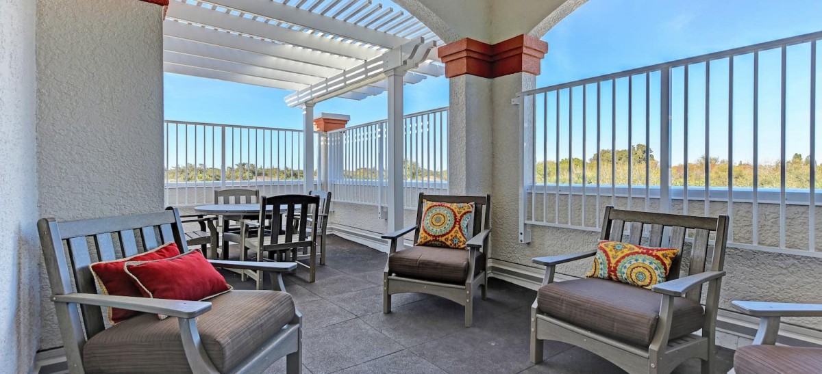 A stylish outdoor patio with comfortable seating and a pergola roof.