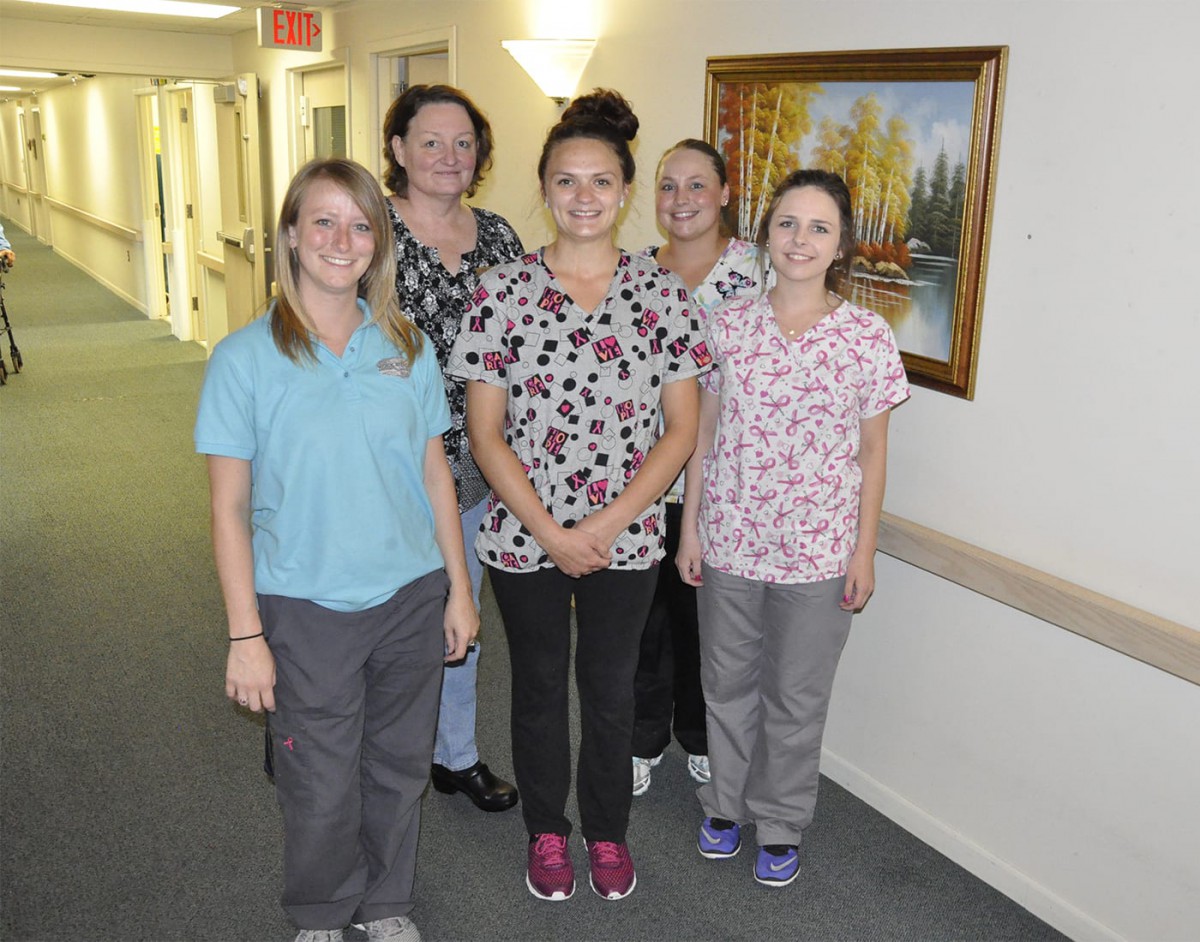 A group of healthcare professionals in uniforms standing in a hallway.