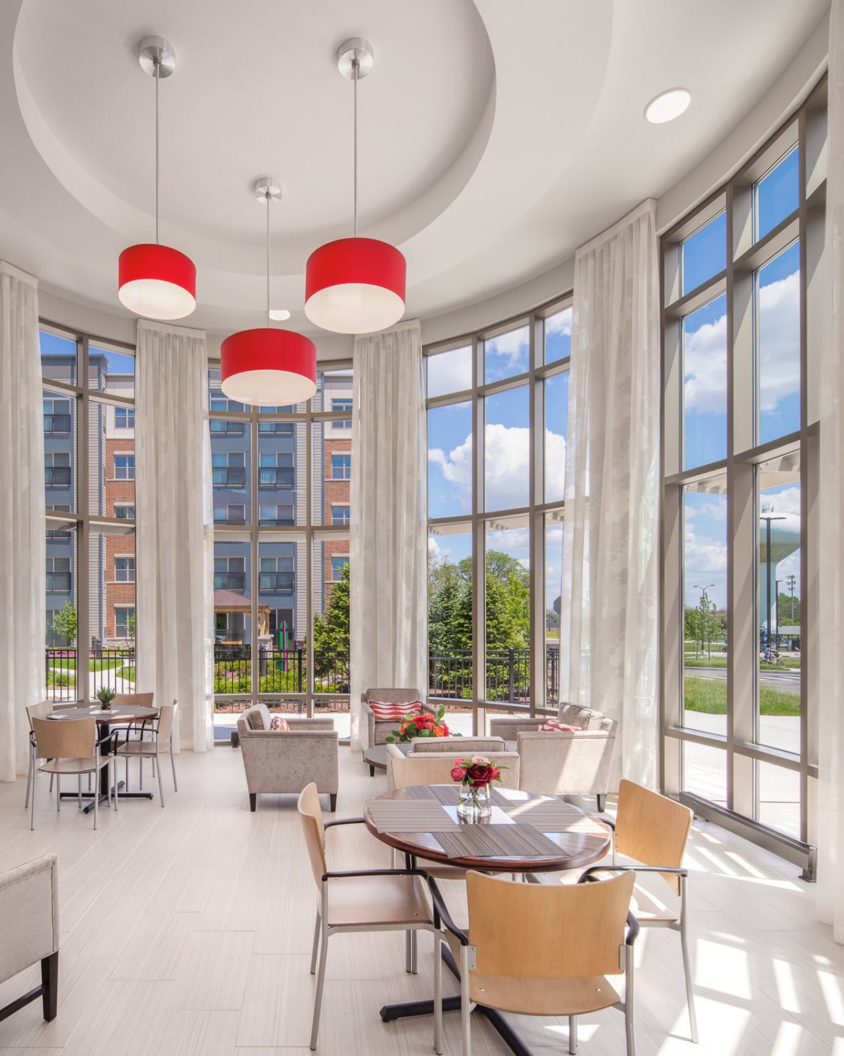 A modern seating area with large windows and red-accented lighting.