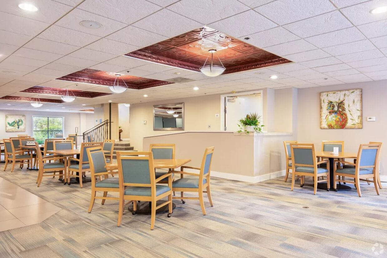 A modern dining area with tables and chairs, featuring stylish ceiling lights.