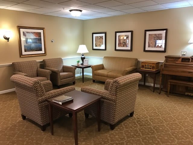 A cozy living room with comfortable seating, artwork on the walls, and a warm, inviting ambiance.