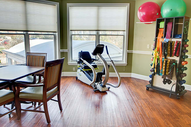 An indoor exercise space featuring an elliptical machine and therapy equipment.