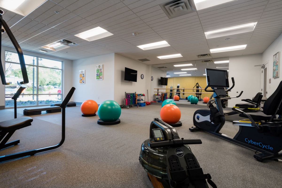 A spacious gym equipped with exercise balls and cardio machines, designed for fitness activities.